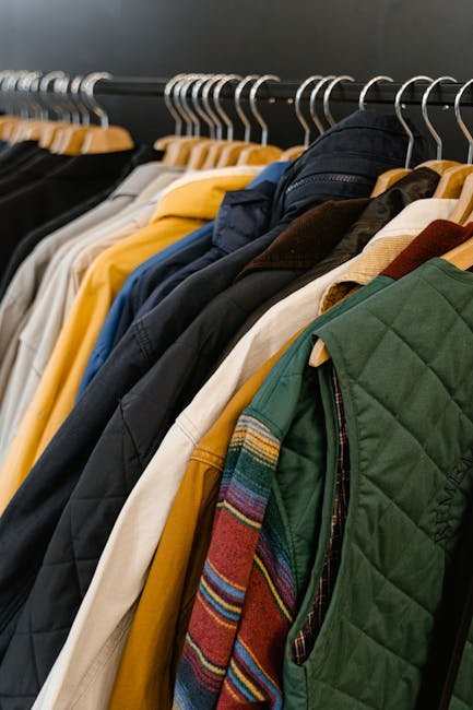 A stylish assortment of jackets and vests neatly hanging in a boutique store display.